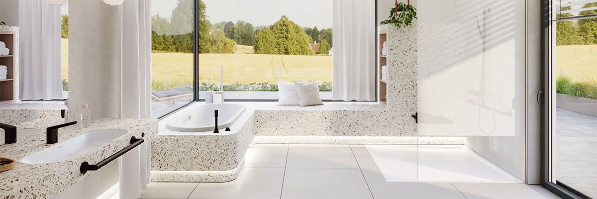 Ein großes Badezimmer mit verschiedenen barrierereduzierenden Besonderheiten, wie einem unterfahrbaren Waschtisch, einem Duschsitz und einer Duschreling.